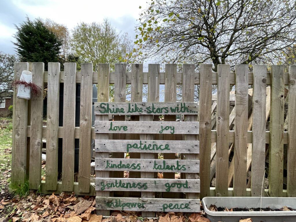Image showing a garden fence with a wooden pallet against it