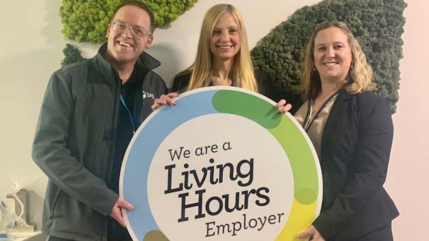 Team holding "we are a living hours employer"